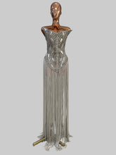 Load image into Gallery viewer, Silver Jazz Era gown featuring a structured crystal-embellished bodice with Art Deco geometric detailing and dramatic floor-length silver fringe.