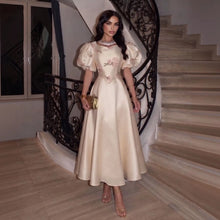Load image into Gallery viewer, Ivory Regency-inspired formal gown with dramatic puff sleeves, blush floral embroidery, fitted waist and full A-line skirt.