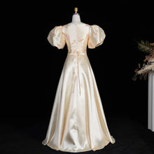 Load image into Gallery viewer, Ivory Regency-inspired formal gown with dramatic puff sleeves, blush floral embroidery, fitted waist and full A-line skirt.