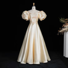 Load image into Gallery viewer, Ivory Regency-inspired formal gown with dramatic puff sleeves, blush floral embroidery, fitted waist and full A-line skirt.