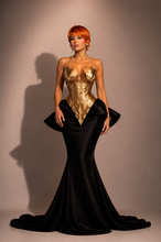 Load image into Gallery viewer, Women wearing the Élysée Sculpted gold couture gown featuring an architectural gold corset, dramatic mermaid silhouette and couture craftsmanship by Mineli Couture